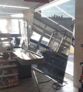 Capra si riflette su una vetrina supermercato e la sfonda