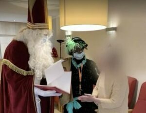 Una immagine del volontario belga travestito da Santa Claus, tra gli anziani ricoverati