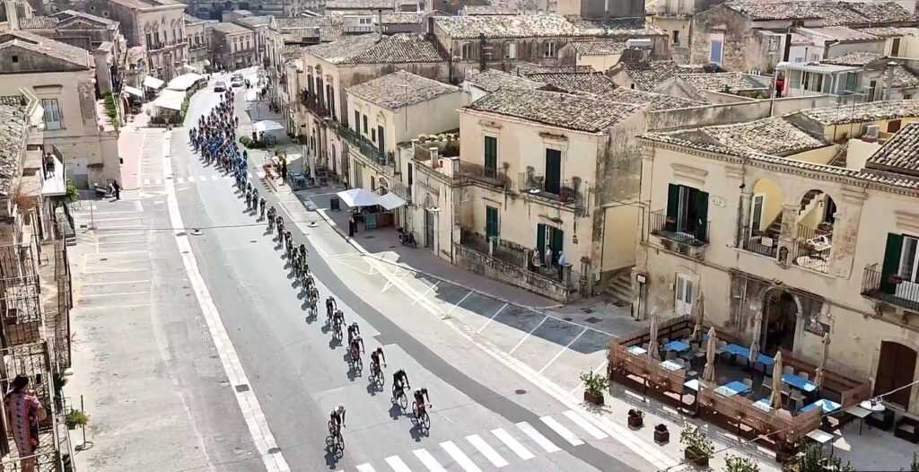 Il passaggio del gruppo di corridori in citt&agrave;