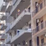 Si affaccia nuda in centro e lancia in strada di tutto