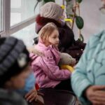 Lo sguardo fisso nel vuoto di una bambina ucraina, mentre abbandona Dnipro