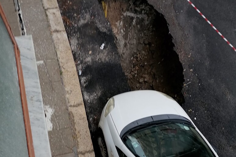 Manto stradale cede per la pioggia, ruota di un’auto nella buca