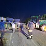 Rimorchio di trattore con carico di fieno si ribalta, auto gli finiscono contro